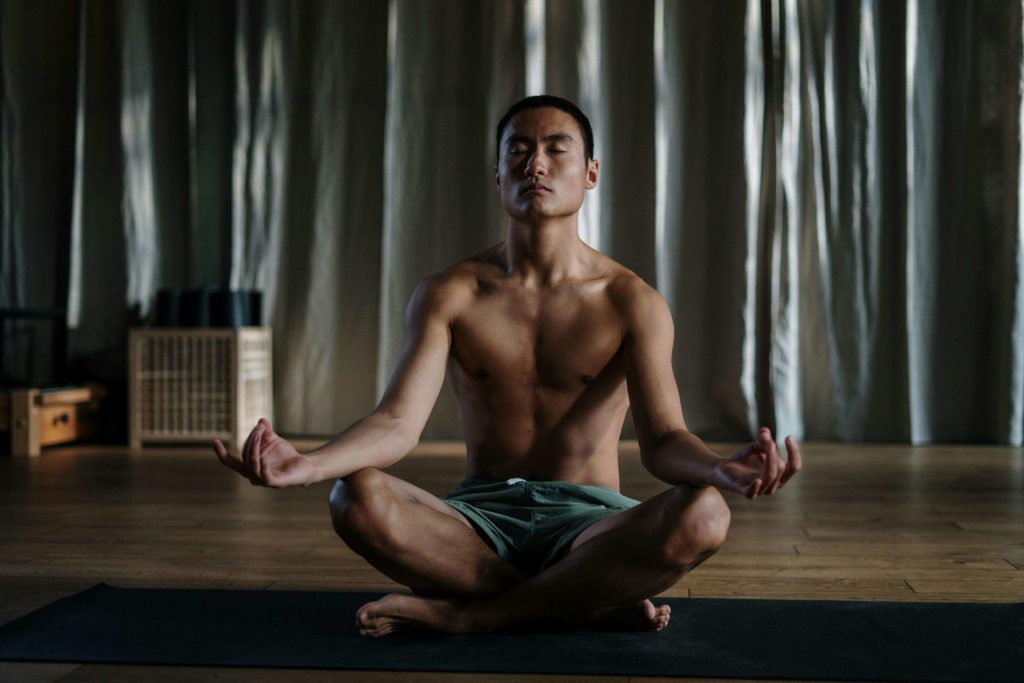 a shirtless man meditating