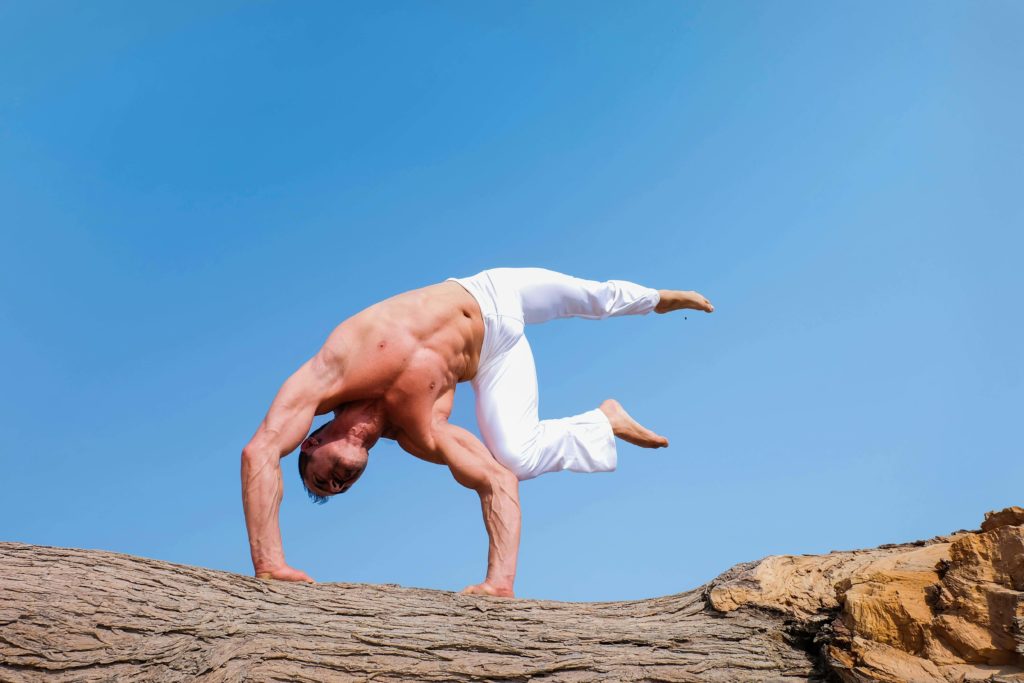 a man doing a yoga pose standing on his hands