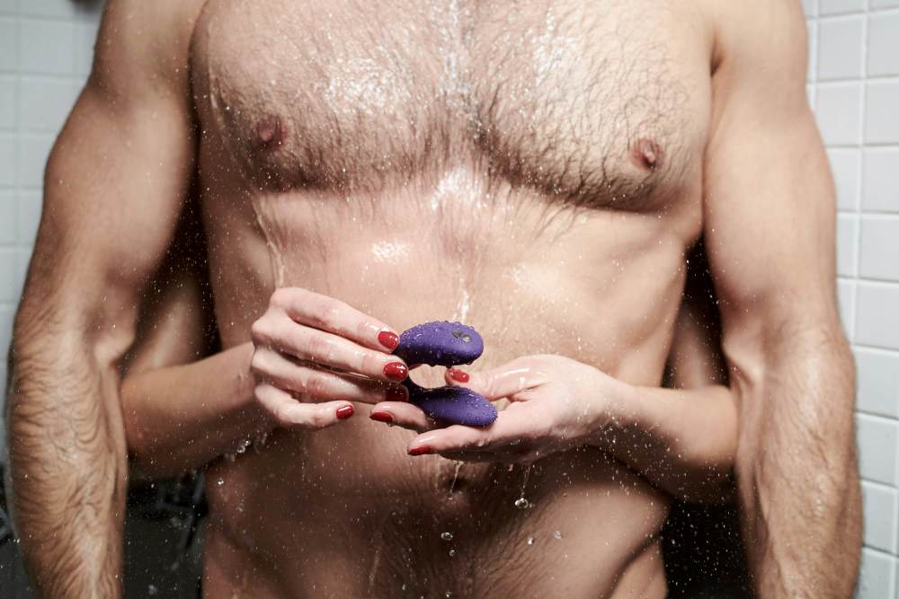 A couple in the shower with a sex toy