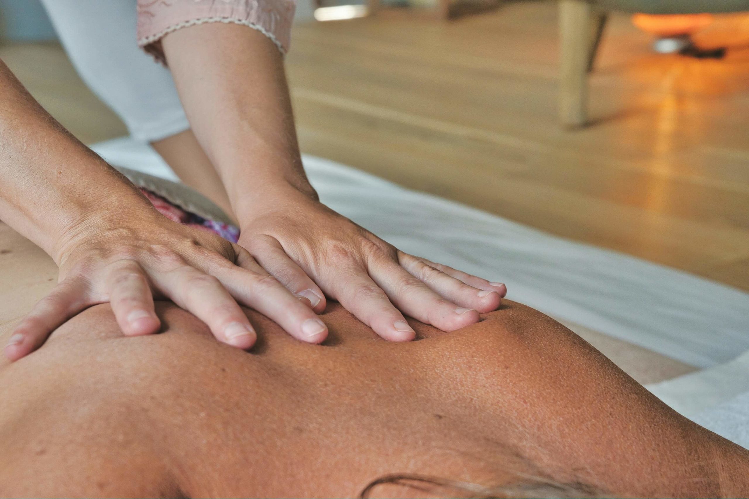 a masseuse using two whole hands to massage a client's back