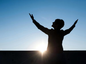 a person raising their arms to the sun